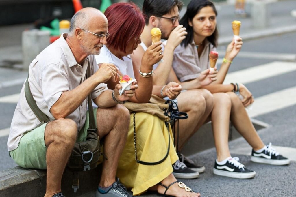 grupo-de-pessoas-sentadas-na-calcado-tomando-sorvete