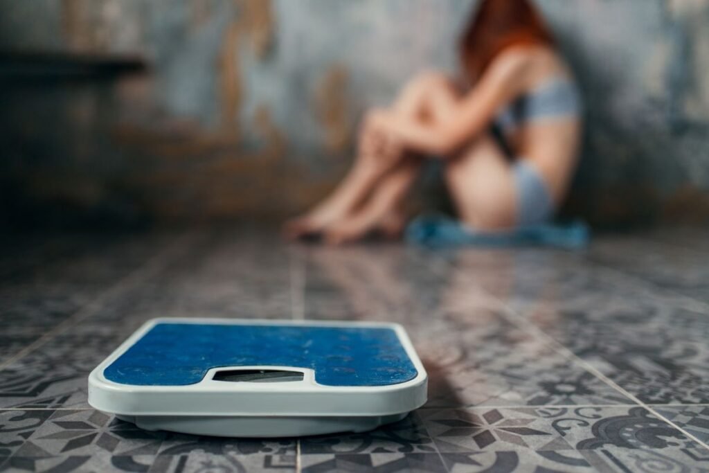 mulher com anorexia nervosa perto da balança