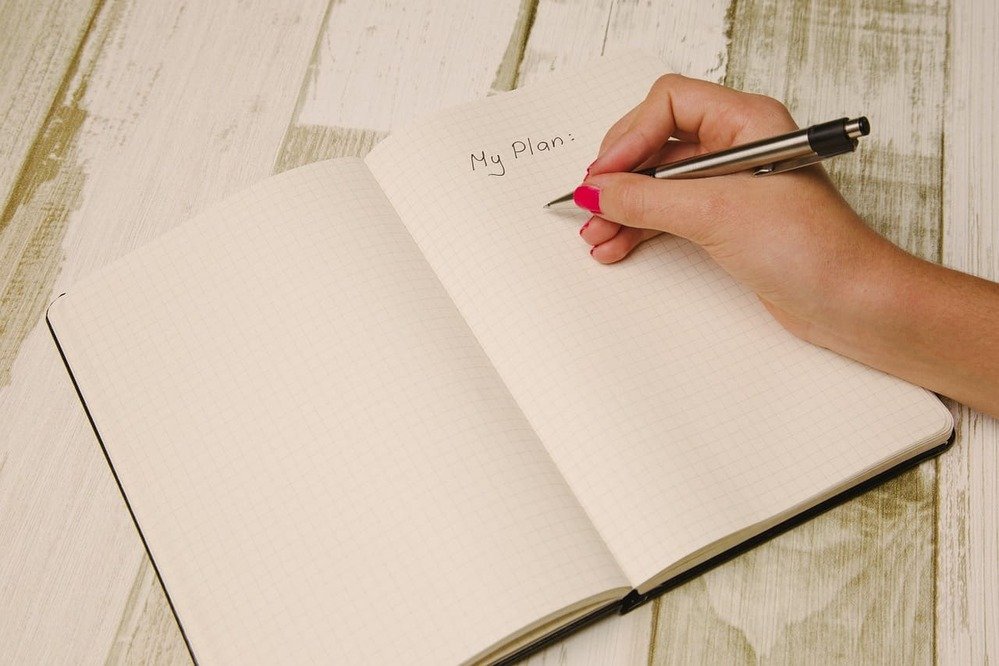 Alguém escrevendo em um caderno