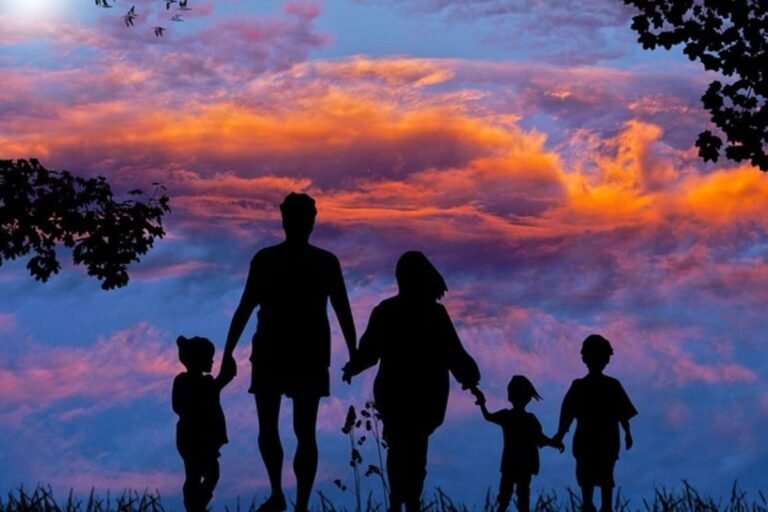 Família de mãos dadas andando na rua ao antardecer